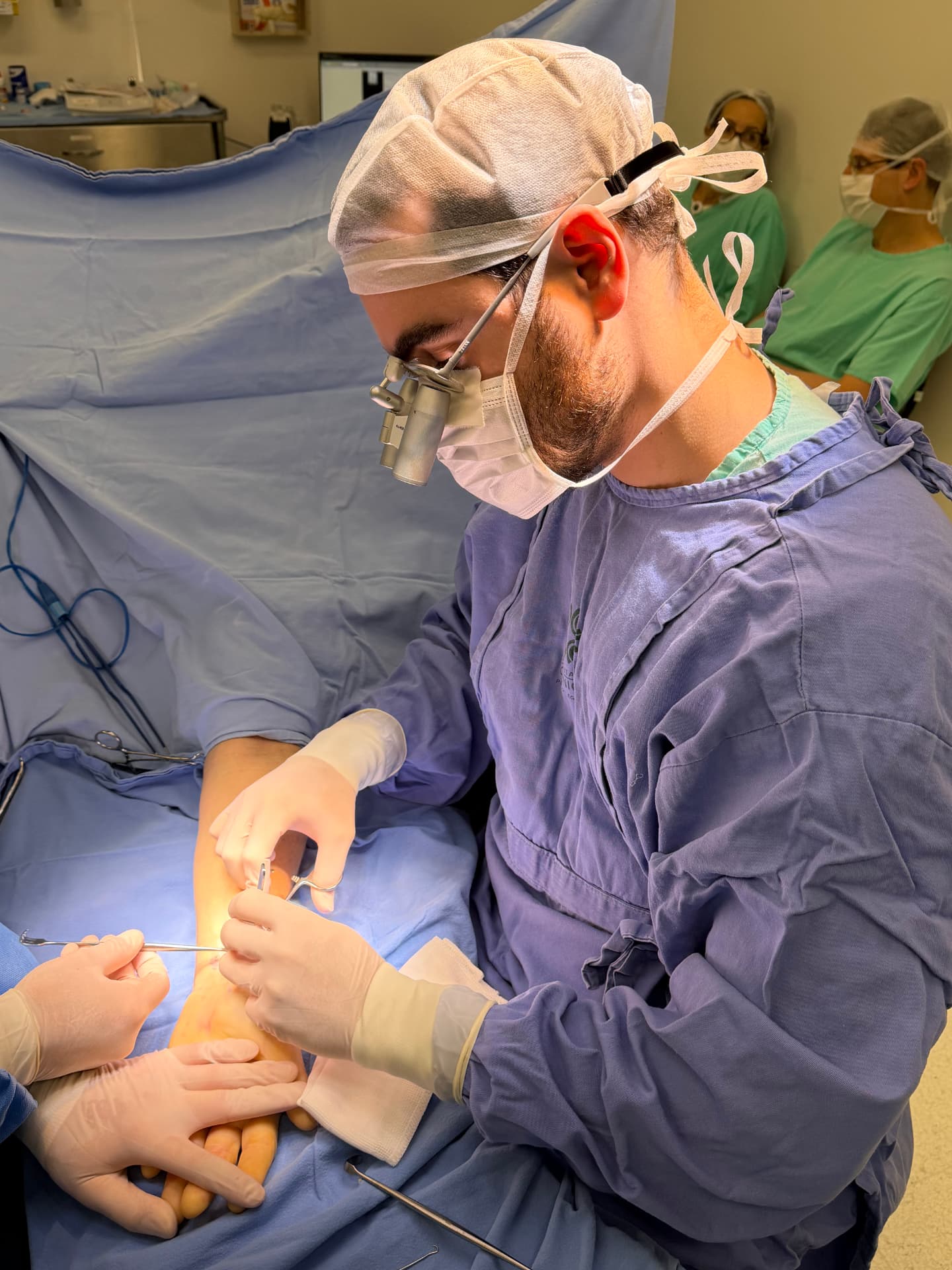 Dr. Matheus H. da Costa realizando procedimento cirúrgico da mão em centro cirúrgico